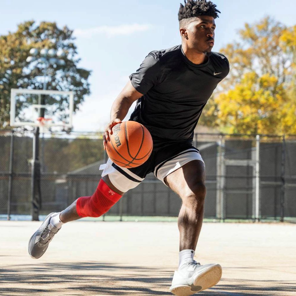 Basketball player dribbling on outdoor court in the daytime