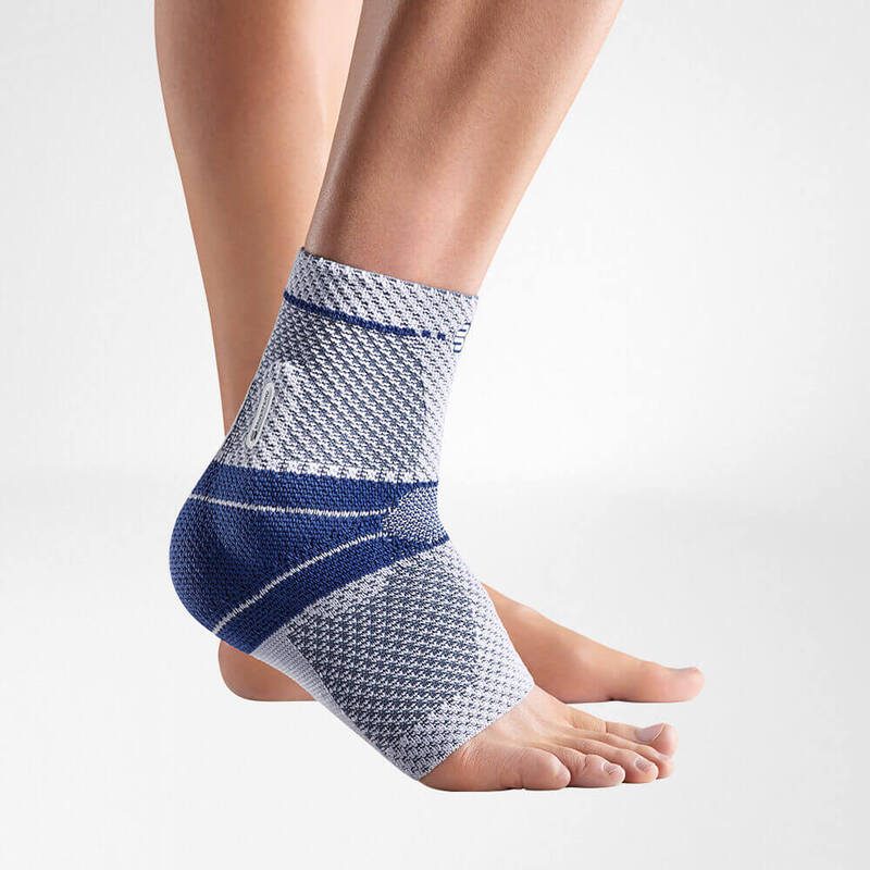 Close-up view of a blue and gray ankle support brace on a person's left foot against a white background