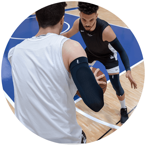 Two basketball players competing against each other while wearing Dirk Nowitzki Signature Line products.