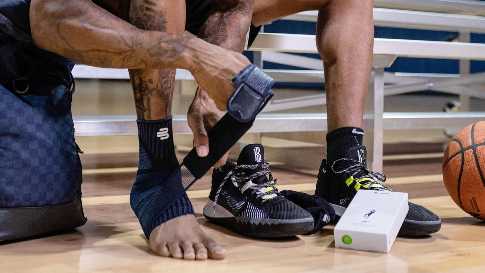 Athlete wrapping the Sports Ankle Support Dirk Nowitzki's figure-8 strap system before playing basketball.