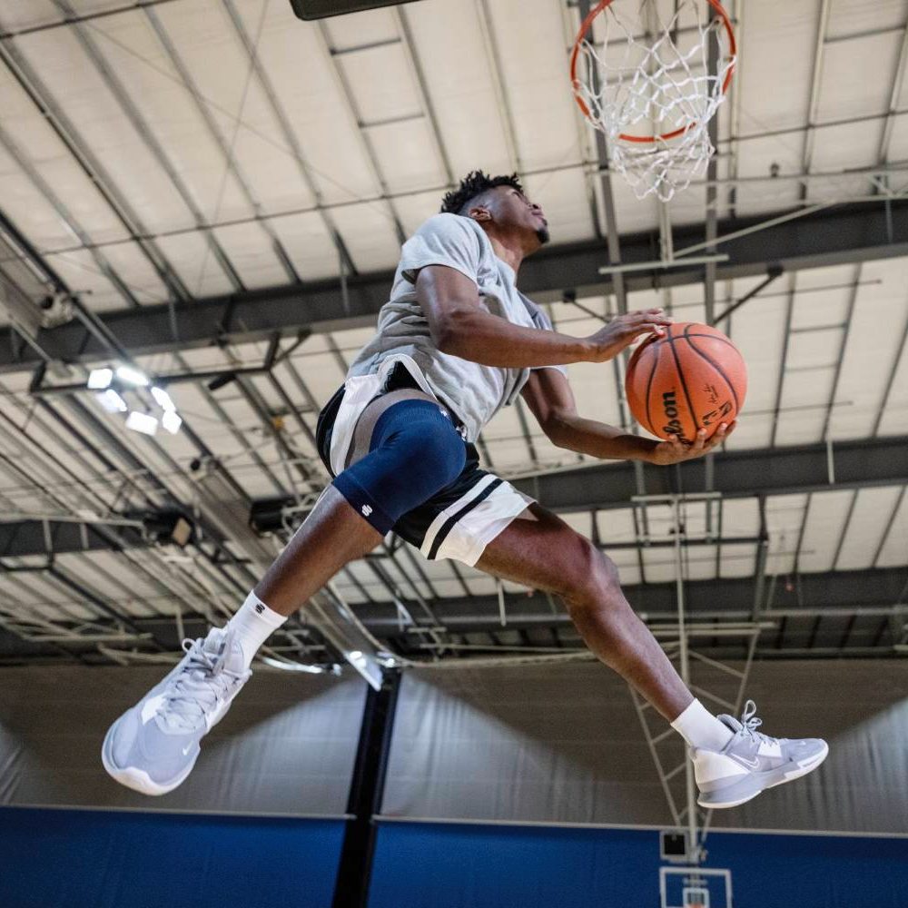 Basketball player dunking in an indoor gym