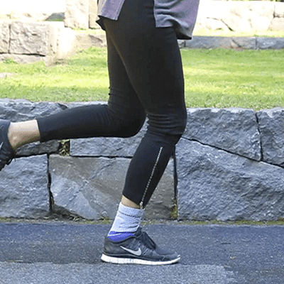 Close-up of a person performing single leg balance exercises while outside and wearing Bauerfeind's MalleoTrain ankle brace.