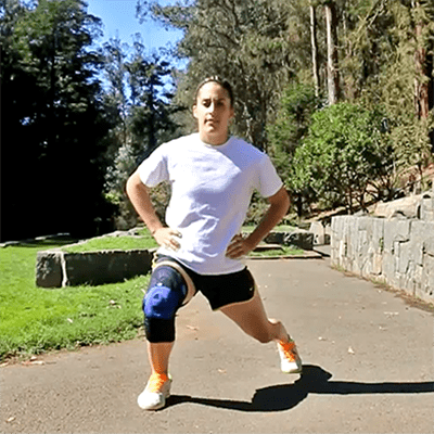 Woman performing clock lunge exercise while outside wearing Bauerfeind's GenuTrain P3 patella knee brace.