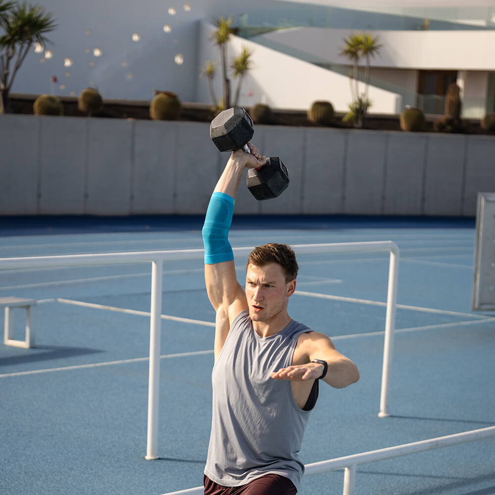 Image of man performing single-arm dumbbell exercise wearing Compression Elbow Support