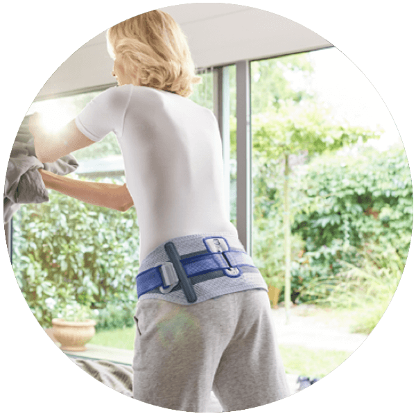 Person wearing Bauerfeind's SacroLoc SI joint belt while doing household chores.