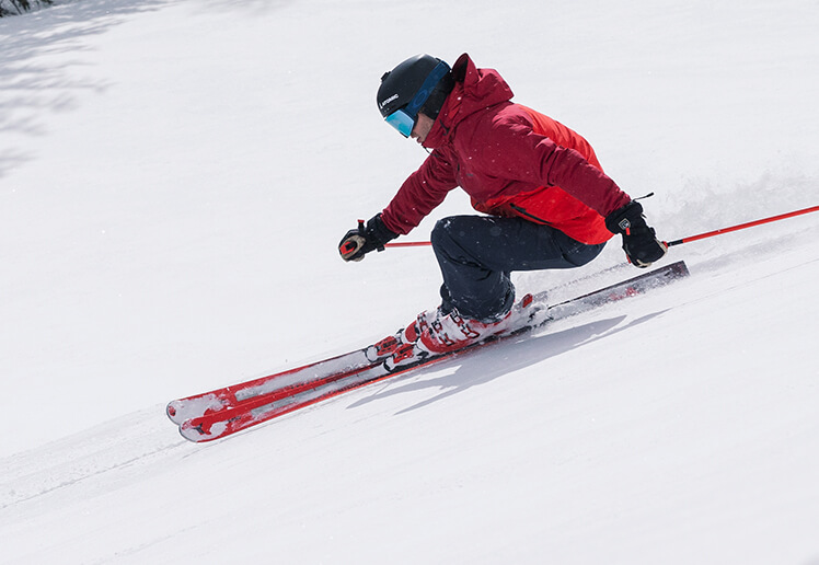 Image of man skiing down snowy mountain landscape.