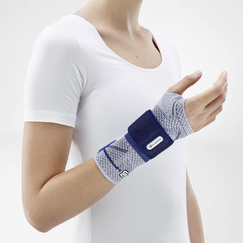 Image of the side of Bauerfeind's ManuTrain wrist brace while being worn by a person in front of a gray background.