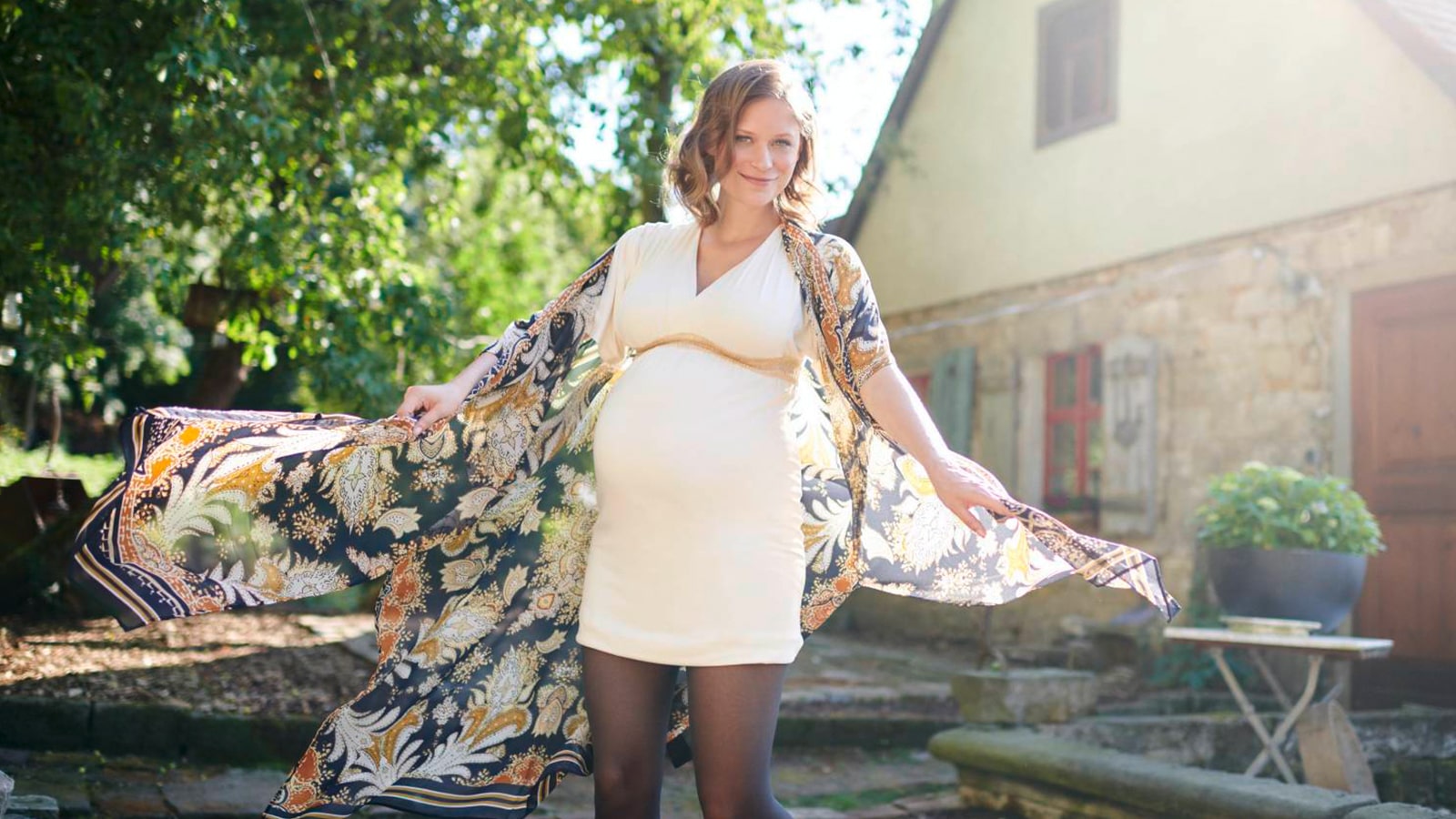 Pregnant woman posing for a photo while wearing Bauerfeind's VenoTrain micro Compression Stockings.