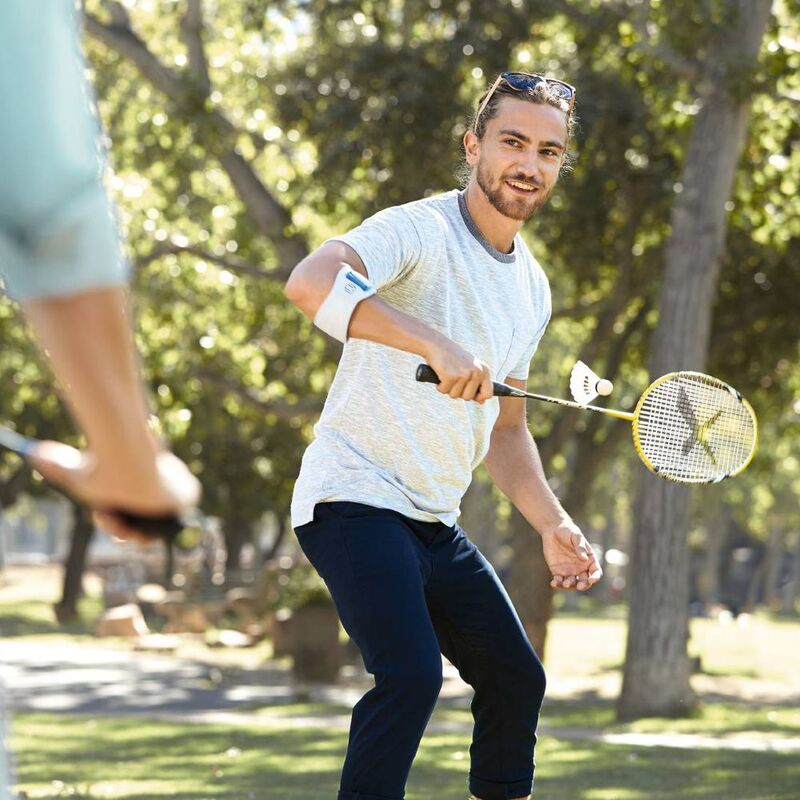 Image of a man wearing Bauerfeind's EpiPoint elbow strap while playing badminton.