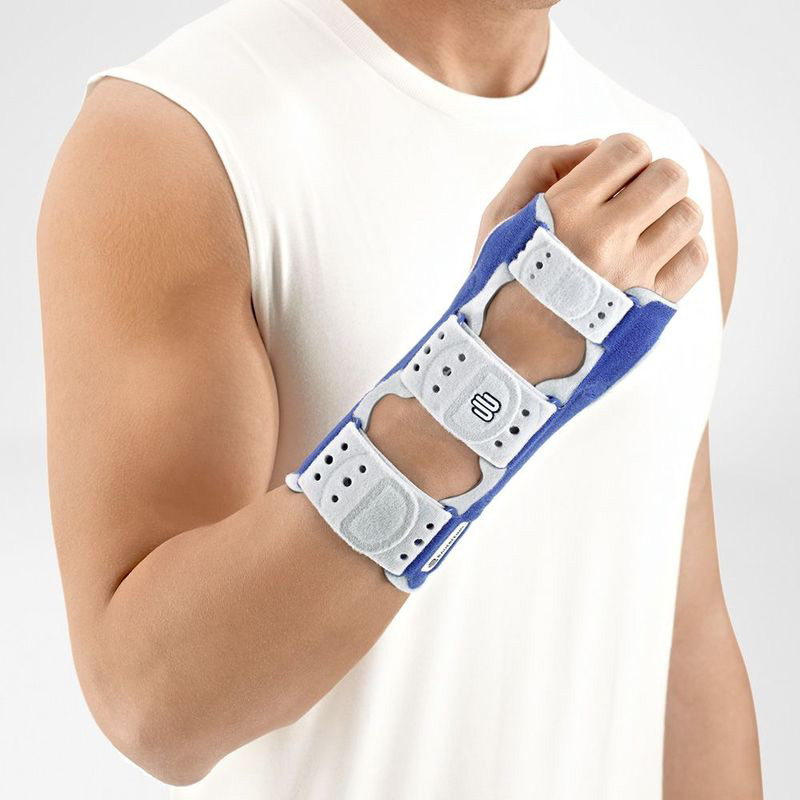 Man wearing Bauerfeind's ManuLoc wrist support splint in front of a gray background.