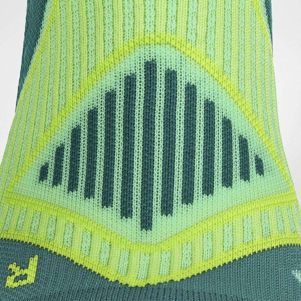 Close-up of a green and yellow knitted fabric with an intricate geometric pattern and the Woolrich logo.