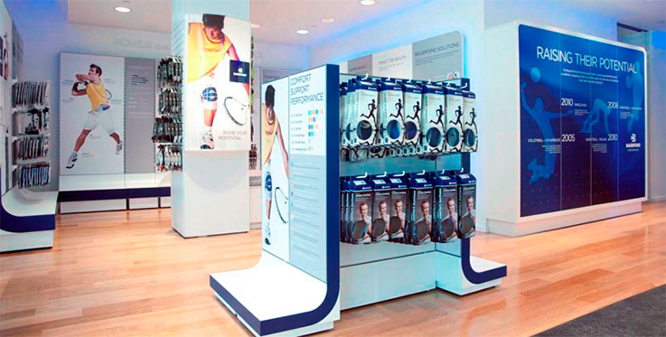 Modern sports retail store interior with promotional displays for athletic gear and history timeline of a sports brand.