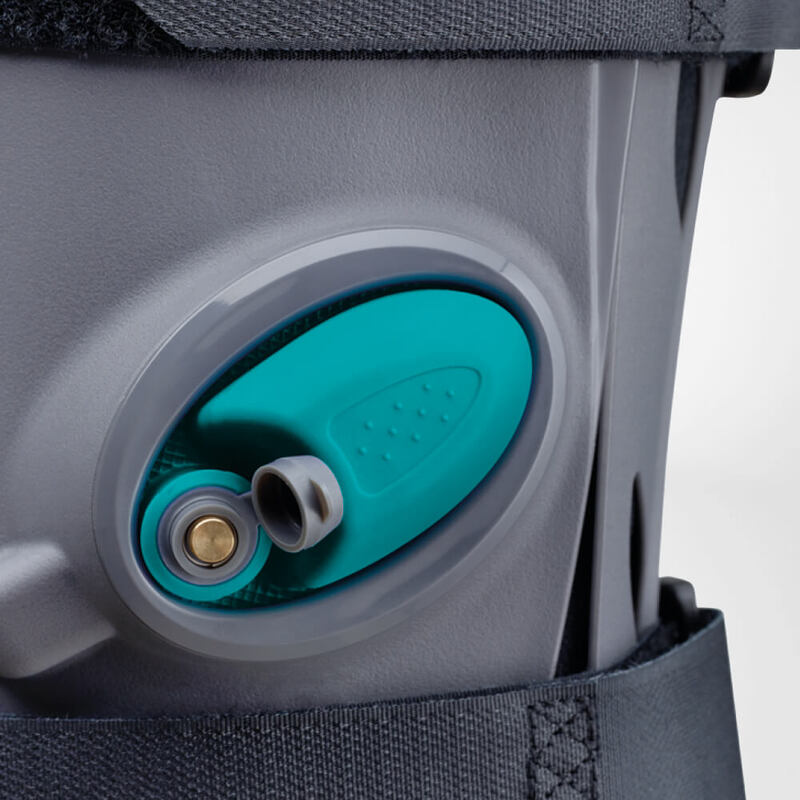 Close-up view of a modern, gray and turquoise knee brace highlighting its adjustable straps and sturdy support mechanism.