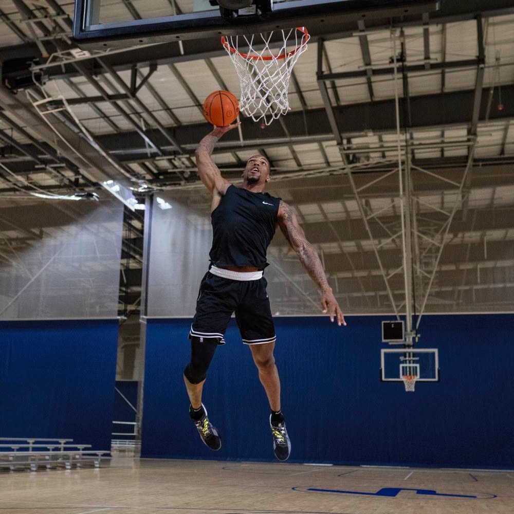 Basketball player performing a slam dunk in an indoor basketball court