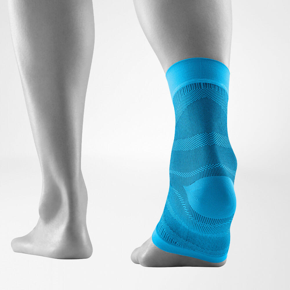 Close-up of a leg wearing a blue compression ankle brace for support and pain relief.