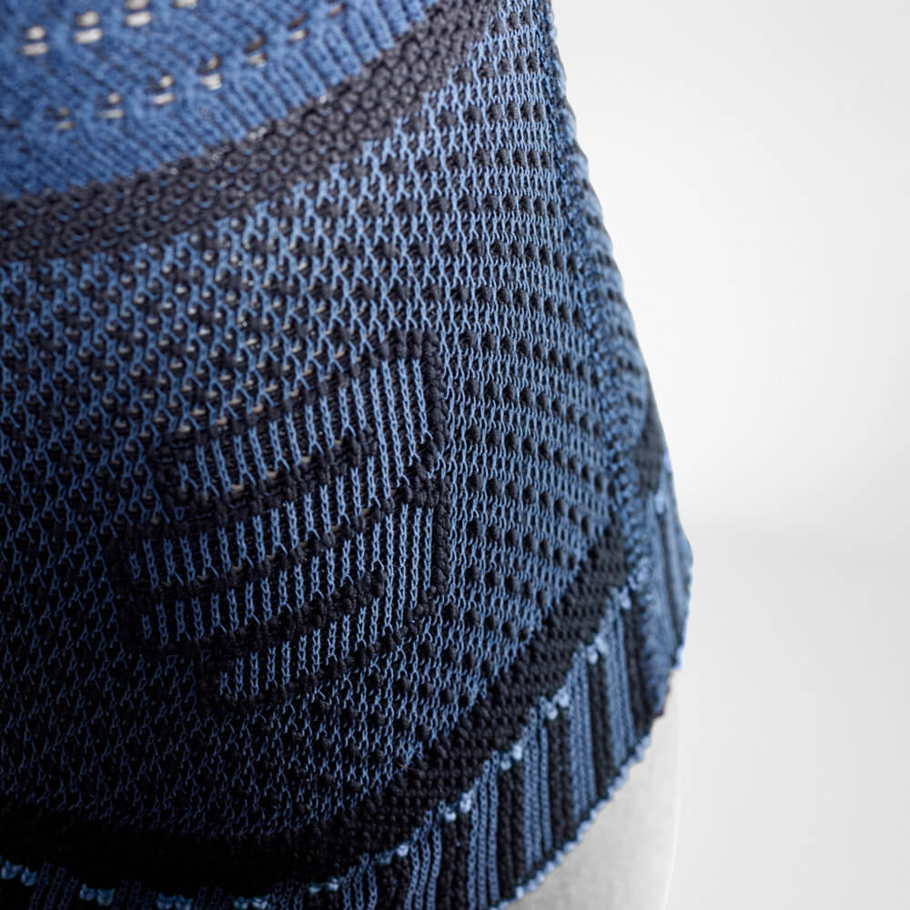 Close-up of blue knitted fabric with intricate patterns and textures.