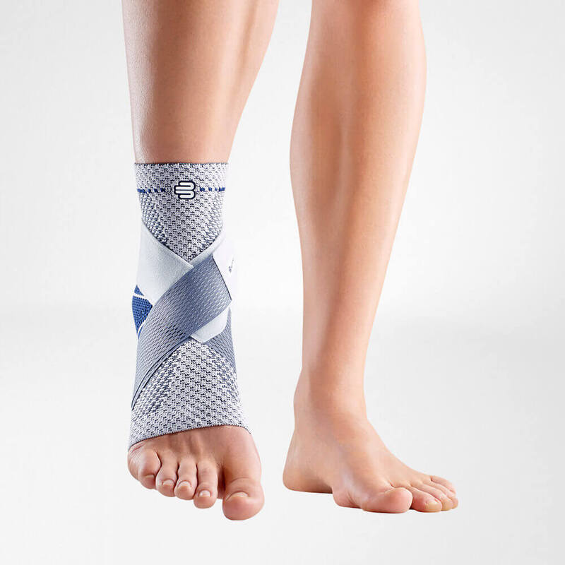 Close-up of a beige ankle support brace on a human leg, showcasing its adjustable straps and breathable fabric design against a plain light background.