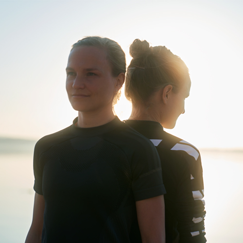 Lisa and Anna Hahner posing for a picture in front of a lake in the morning.