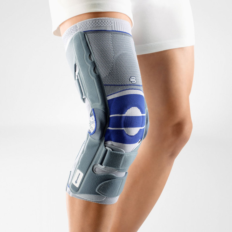 Close-up view of a person wearing an advanced blue and gray orthopedic knee brace with adjustable straps for injury support.