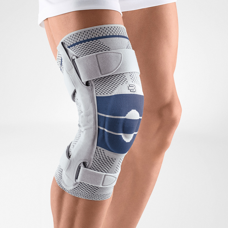 Close-up view of Bauerfeind's titan GenuTrain S hinged knee brace on a person's leg, showcasing adjustable straps and knee pad for joint stability and injury recovery.