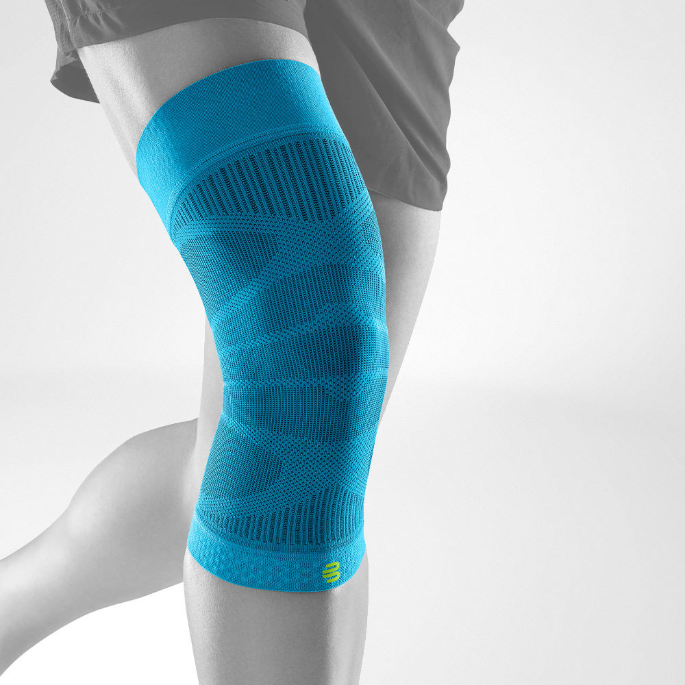 Person wearing a teal blue knee compression sleeve for support and recovery.