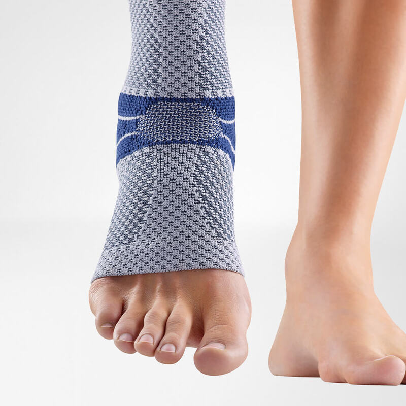 Close-up of a gray and blue ankle support brace on a person's left foot, showing detailed fabric texture and supportive bands, isolated on a white background.