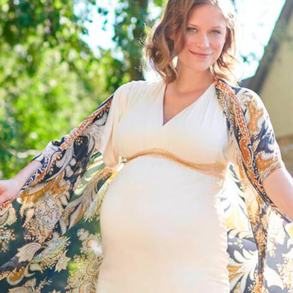 Pregnant woman posing for a photo while wearing Bauerfeind's VenoTrain micro Compression Stockings.