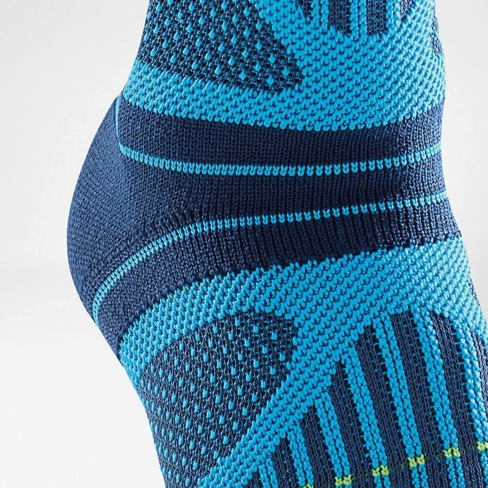 Close-up of a blue and dark blue athletic compression sock showcasing intricate knit patterns.