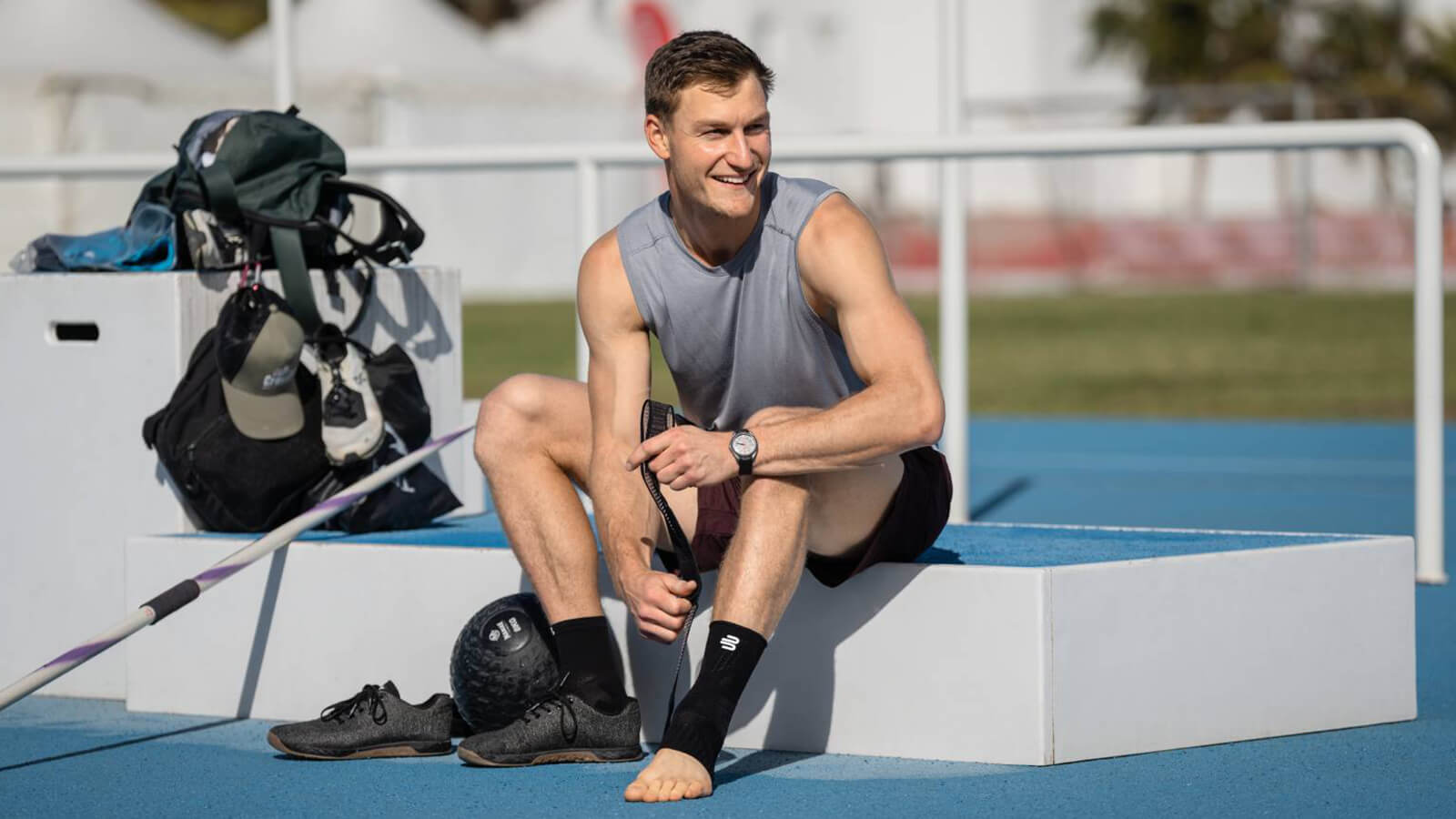 Olympic Gold Medalist Thomas Röhler adjusting the figure-8 strap system on Bauerfeind's Sports Ankle Support before training in the javelin throw. 