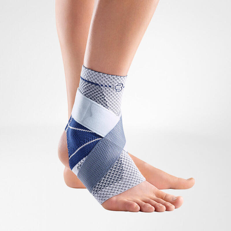 Close-up view of a blue and white ankle brace on a human foot, isolated on a white background, showcasing the support and fit of the brace.