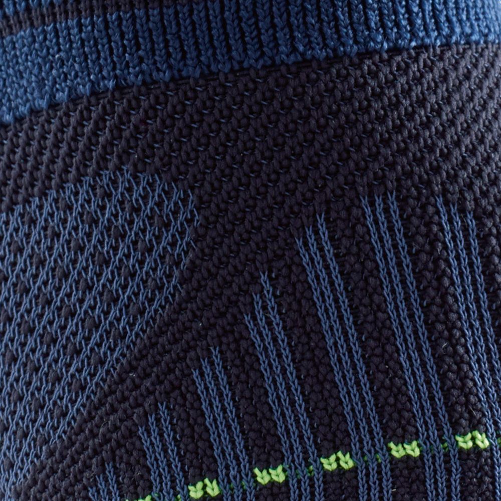 Close-up of a dark blue and green knitted fabric with intricate patterns