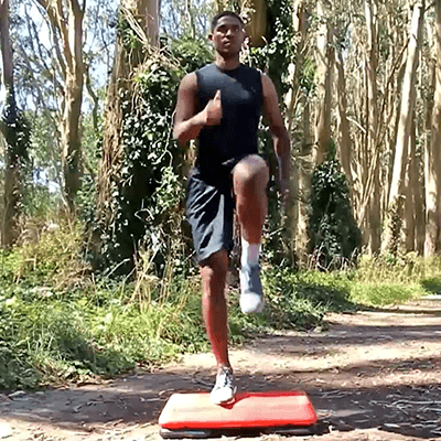 Male athlete performing the step ups plus exercise while outside and wearing Bauerfeind's AchilloTrain Achilles tendonitis ankle brace.