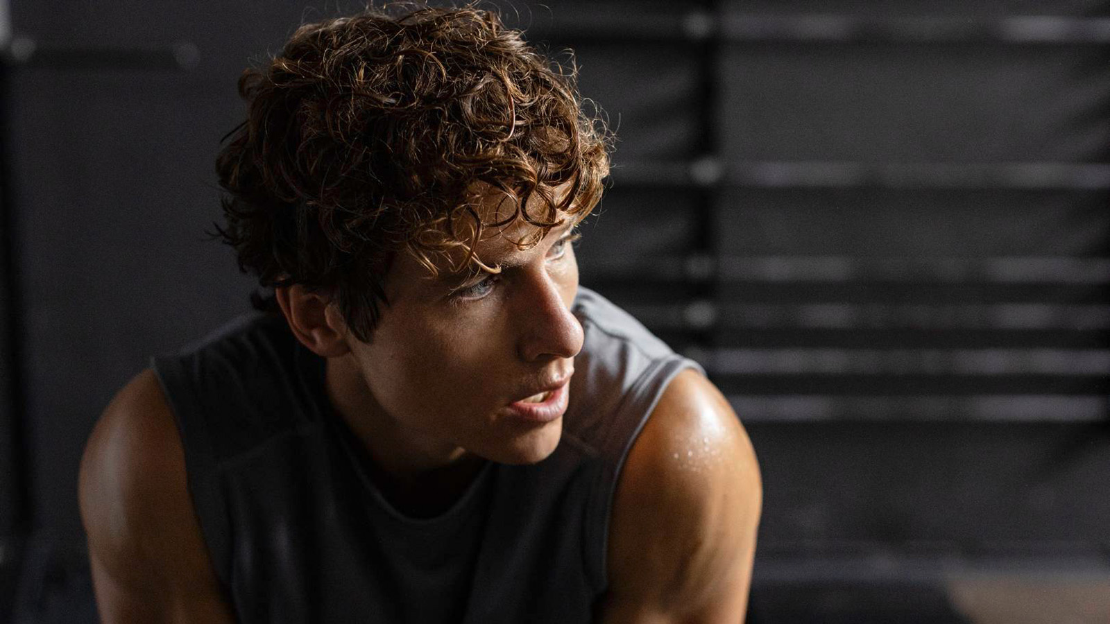 Image of man taking a break in the middle of working out at a fitness center.