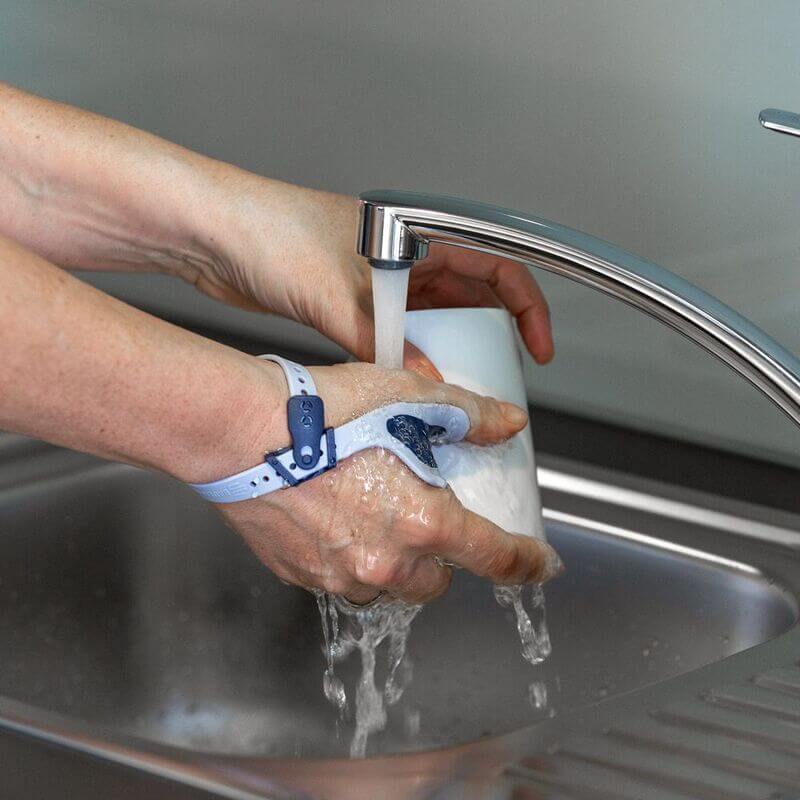 Image of a person washing their hands with soap while wearing Bauerfeind's RhizoLoc OA arthritis thumb brace.