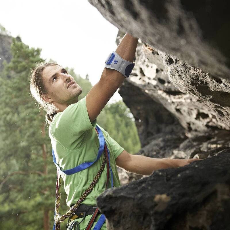 Image of a man wearing Bauerfeind's EpiPoint elbow strap while mountain climbing.