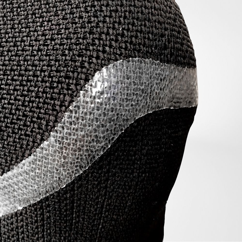 Close-up of black textured fabric with a transparent bubble wrap strip