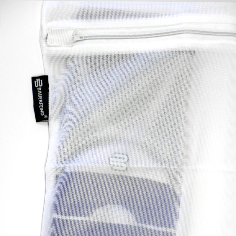 Close-up view of a white zippered mesh laundry bag with a visible logo tag and fine mesh texture, designed for delicate garments.