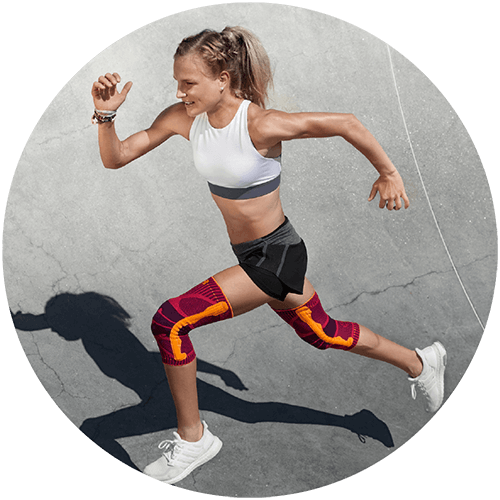 Woman running on concrete while wearing Bauerfeind's Sports Knee Support.