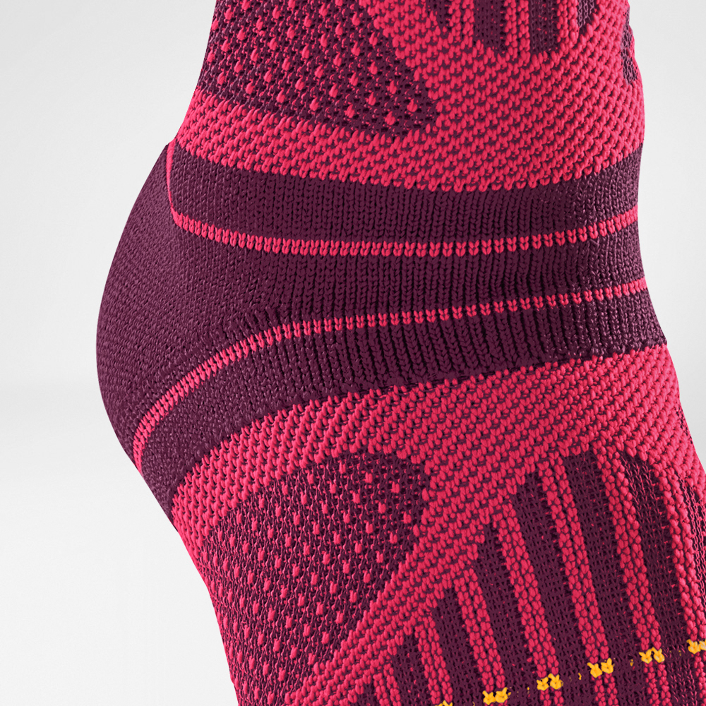 Close-up of purple and red compression sock with intricate knit pattern for enhanced support